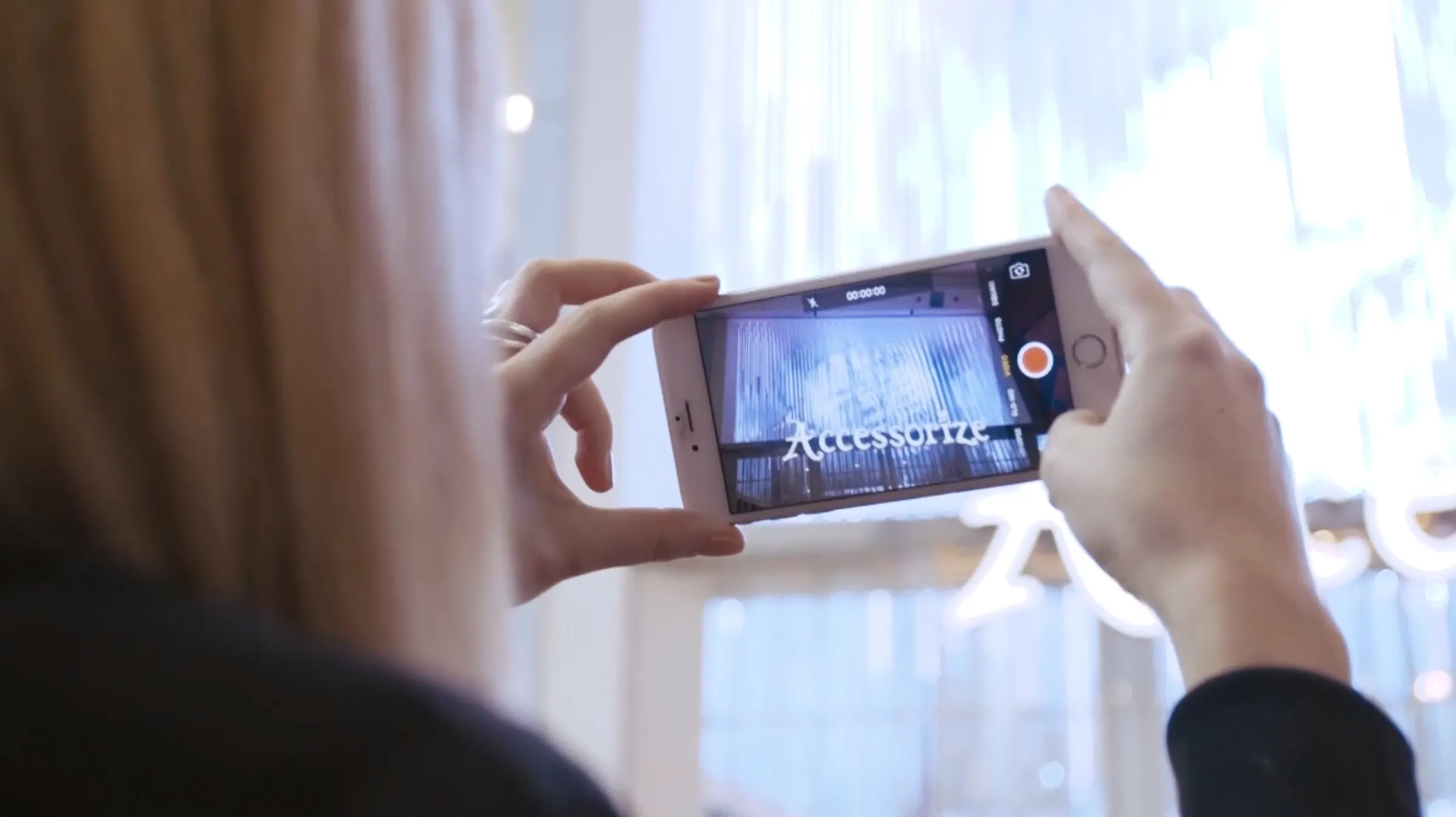 Francesca filming the Accessorize LED shopfront on her phone