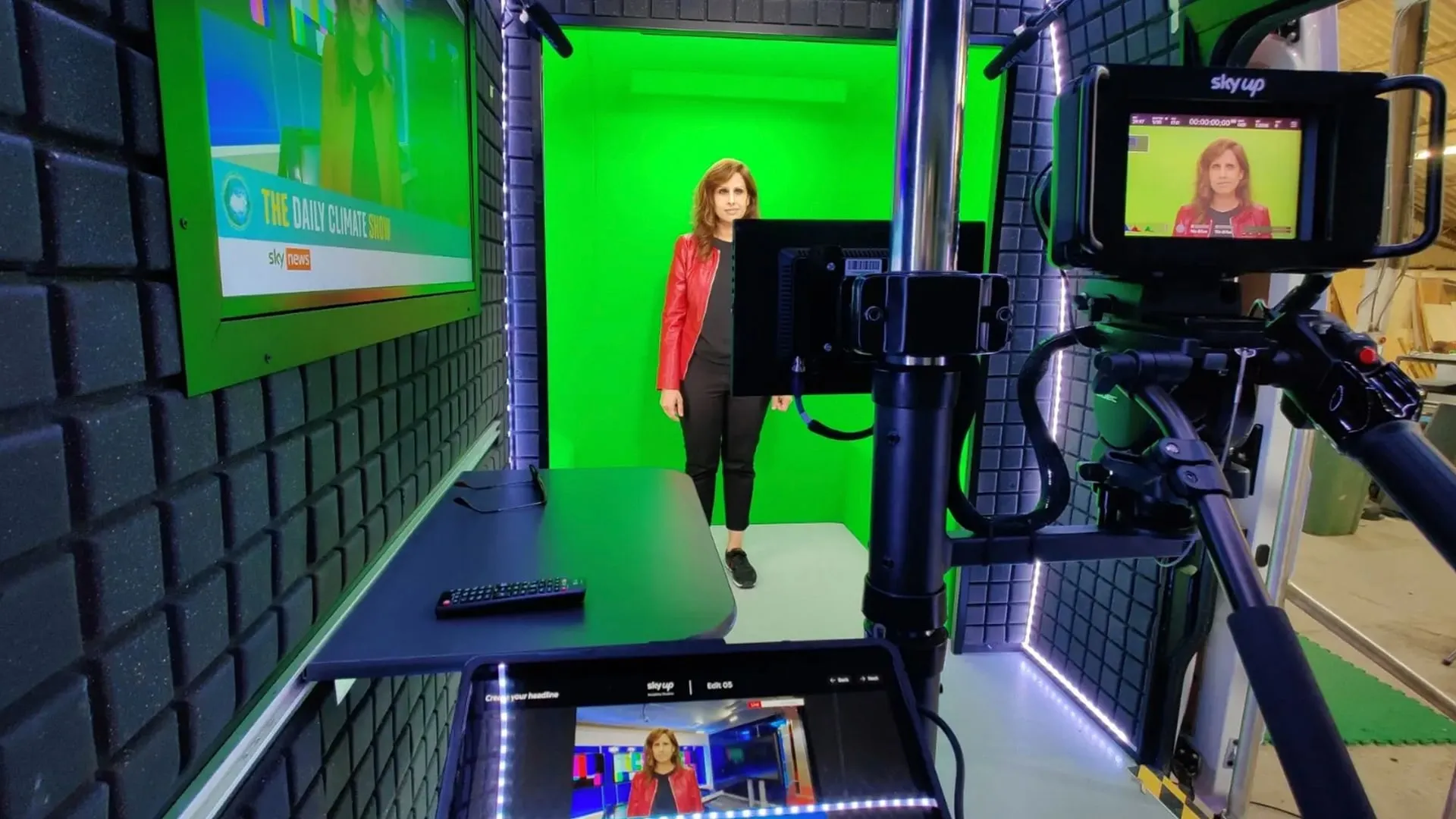 A student presenting on a green-screen set, seen through the camera monitor