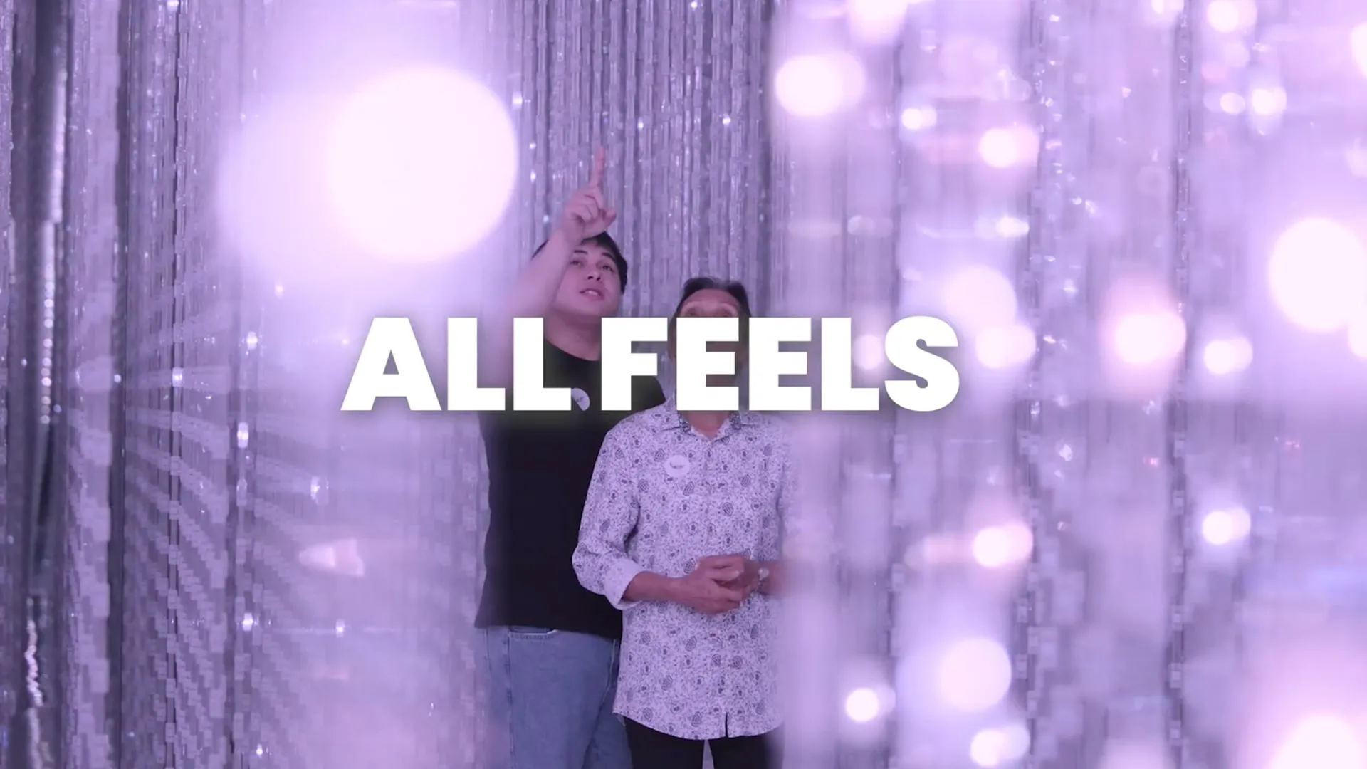 A grandmother and grandson inside a sparkling light installation