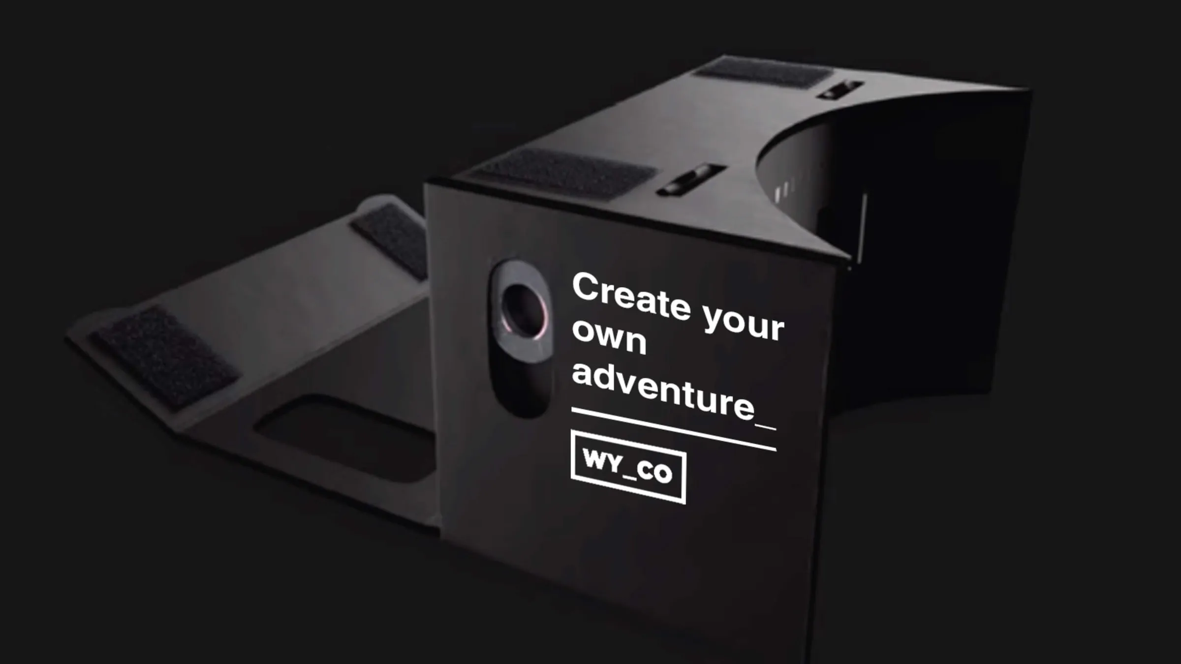 A black cardboard VR headset printed 'Create your own adventure'