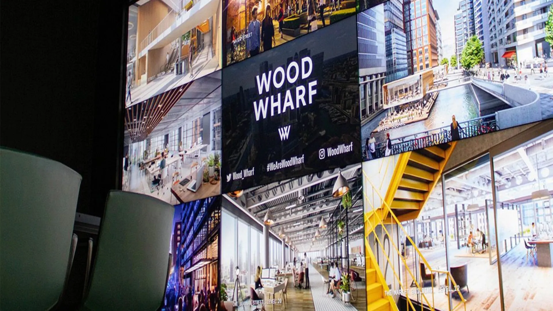 A wall of screens showing Wood Wharf imagery