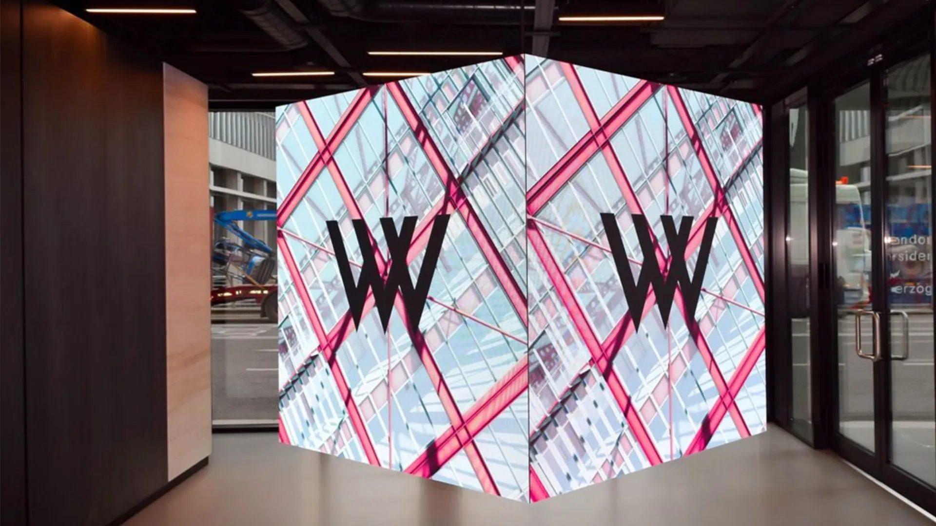 A large-scale video wall showing the Wood Wharf logo