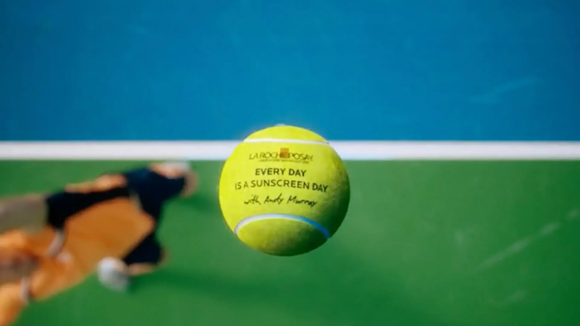 A tennis ball printed with 'Every day is a sunscreen day' and Andy Murray's signature
